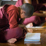 Mladý mnich studující v klášteře