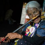 Potetovaná babička ve státě Chin hraje na nosní flétnu (foto: Julia Polok)
