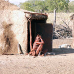 Himbská stařenka před hliněnou chýší